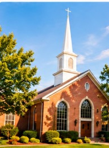 Red brick church with a white steeple under a clear blue sky